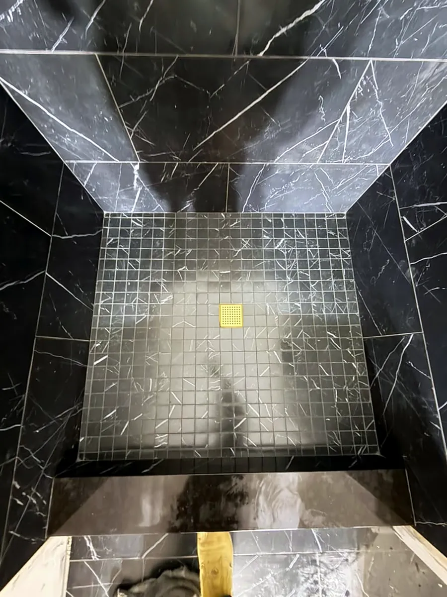 Black marble shower with mosaic pan