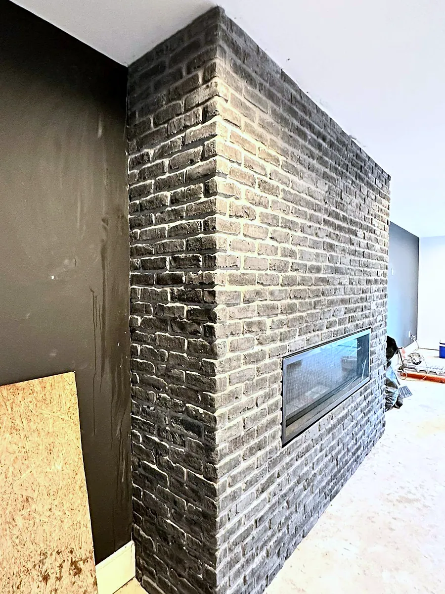 Dark brick feature wall with linear fireplace