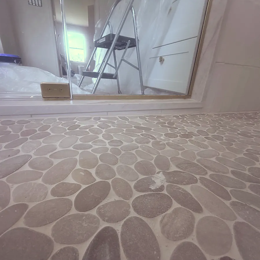 Pebble floor set by hand, master bath