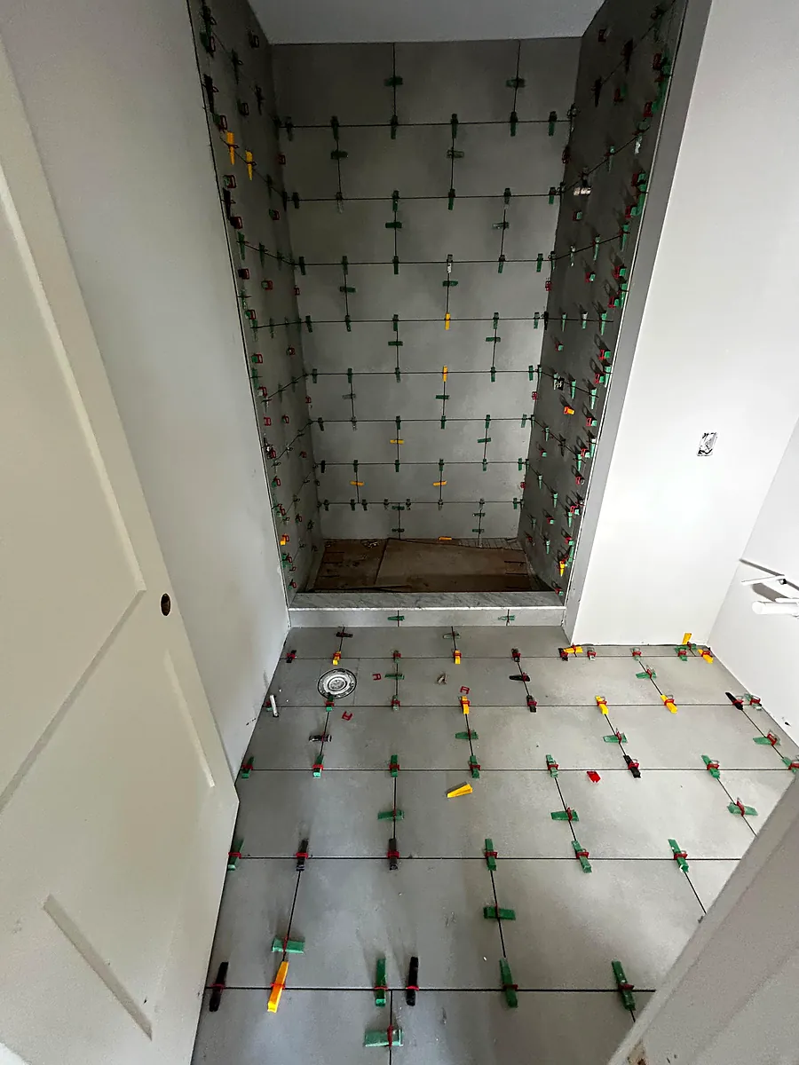 Levelling clips holding a shower wall