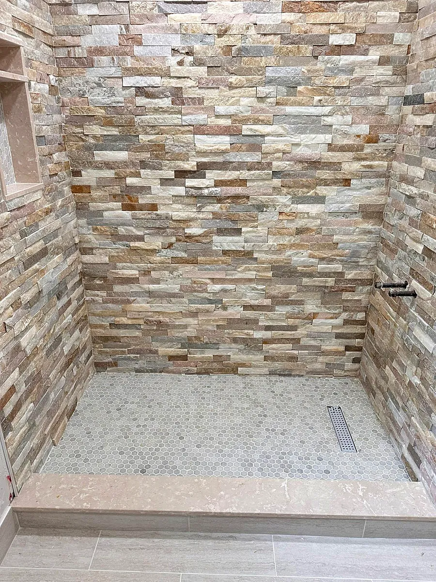 Stacked stone shower with pebble floor